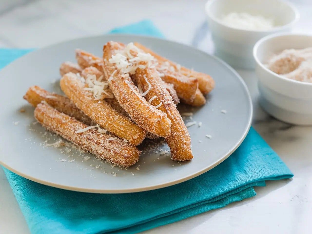Close up of churros with cinnamon coconut sugar on plate
