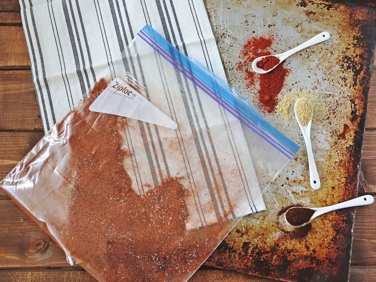 Smoked paprika in Ziplog bag with teaspoons of spices.